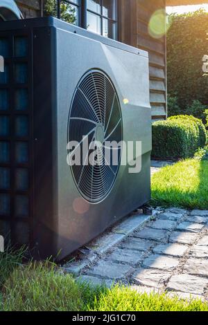 Pompe à chaleur à convertisseur complet près de la maison dans le jardin. Gros plan. Banque D'Images