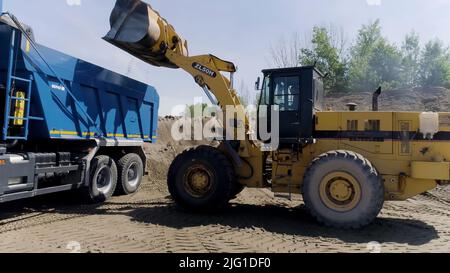 Ekaterinbourg, Russie - août 2021 : le processus de construction. Scène .les gros camions conduisent et construisent quelque chose sur terrain plat à côté de la ville. Haute qu Banque D'Images