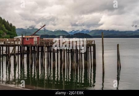 Reflet de la jetée en bois dans l'océan froid à Icy Strait point en Alaska par temps nuageux Banque D'Images