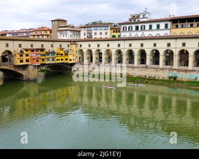 Pont Ponte Vecchio traversant la rivière Arno, avec formation des rameurs sur la rivière, Florence, Toscane, Italie. Banque D'Images