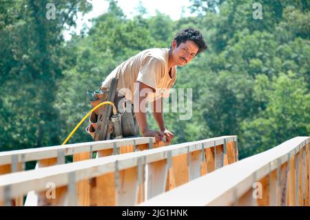 L'équipe de travail construction maison en bois stick built house accueil mesure de coupe à clouer sur journée chaude Banque D'Images