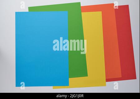 cinq feuilles de papier en bleu, vert, jaune, orange et rouge, couchés l'une sur l'autre, espace de copie Banque D'Images