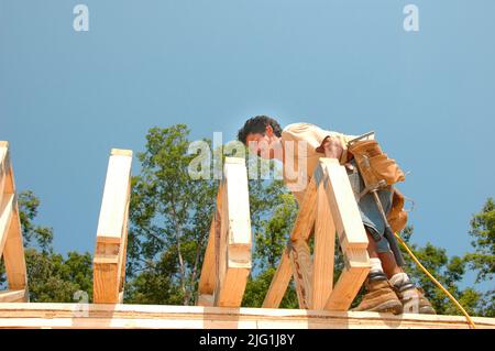 L'équipe de travail construction maison en bois stick built house accueil mesure de coupe à clouer sur journée chaude Banque D'Images