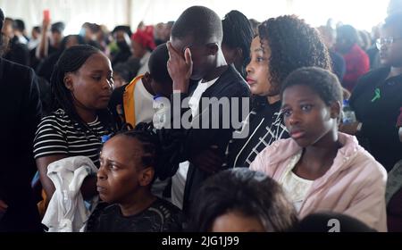 Est de Londres, Afrique du Sud. 6th juillet 2022. Des gens assistent aux funérailles de masse de 21 jeunes victimes de la tragédie de la taverne de la semaine dernière à l'est de Londres, dans la province orientale du Cap, en Afrique du Sud, sur 6 juillet 2022. Le président sud-africain Cyril Ramaphosa a mis mercredi en garde les citoyens contre la consommation d'alcool de moins de deux ans, affirmant que le pays perd sa future génération à cette « cour ». Crédit: Xabiso Mkhabela/Xinhua/Alay Live News Banque D'Images