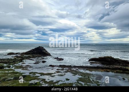 Une plage rocheuse avec des bergs sur l'Islande dans des vents forts avec de puissants surf Banque D'Images