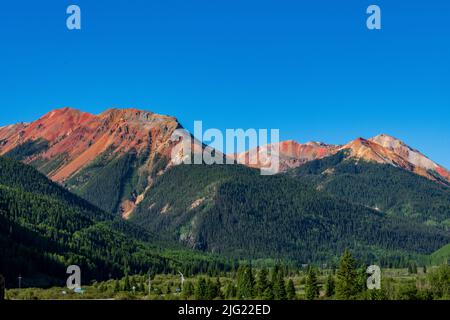 Soleil sur le sommet des montagnes rouges le long du col de Red Mountain dans le Colorado Banque D'Images