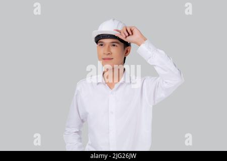 Portrait le jeune homme asiatique est ingénieur portant un casque debout et souriant avec confiance isolé sur fond blanc, beau homme est architecte ou co Banque D'Images