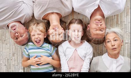 Une famille se liant ensemble et jouant, montrant différentes expressions tout en liant et en appréciant le temps de qualité. Au-dessus du plaisir de faire de la famille Banque D'Images