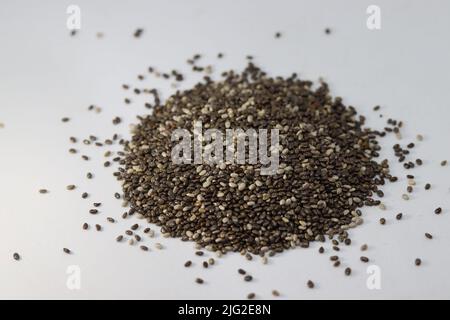 Mise au point sélective sur les graines de Chia isolées sur fond blanc. Accent sélectif sur Salvia Hispanica L.seeds riche en protéines alimentation ingrédient alimentaire. Banque D'Images