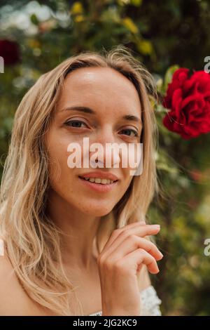 Portrait d'une jeune femme fatiguée près de roses rouges Banque D'Images