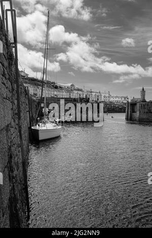 Un yacht de visite s'amarre dans le port intérieur à Porthleven, Cornouailles Banque D'Images