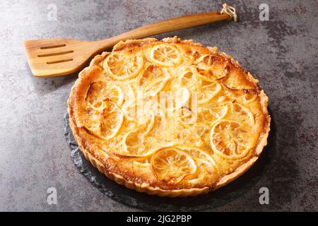 Tarte au citron avec une crème aigre et douce délicate et des morceaux de fruits dans une assiette sur la table. Horizontale Banque D'Images