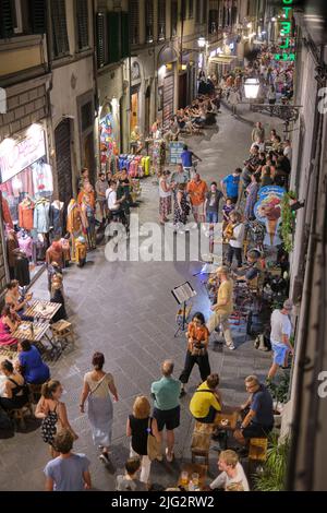 Scène nocturne animée le long de la via Faenza à Florence en Italie Banque D'Images