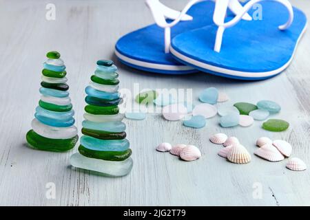 Pyramides de barges de bouteilles en verre polies par la mer sur fond de tongs bleues. Équilibre Zen. Équilibre mental de récupération Banque D'Images
