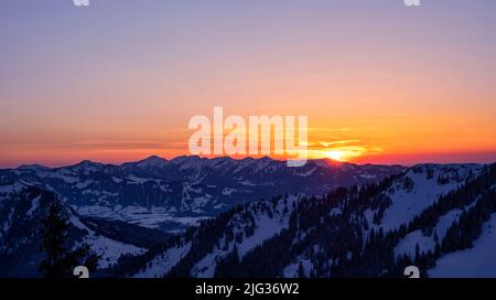 Coucher de soleil coloré sur des montagnes enneigées en hiver. Allgau Alpes, Bavière, Allemagne Banque D'Images