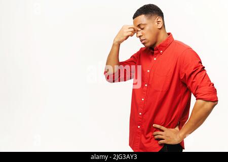 Problème, dépression ou maladie. Portrait de triste seul beau jeune homme en chemise debout, tenant la tête vers le bas et pleurant. Studio d'intérieur isolé sur fond blanc Banque D'Images