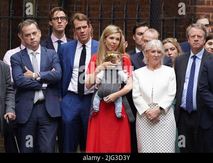 Le ministre sans portefeuille du Cabinet Nigel Adams (à gauche), le secrétaire à la Culture Nadine Dorries (deuxième à droite) et le secrétaire écossais Alister Jack (à droite), se tiennent avec Carrie Johnson, épouse du Premier ministre Boris Johnson, qui accueille leur fille Romy, alors qu'il lit une déclaration devant le 10 Downing Street, Londres, La démission officielle de son poste de chef du Parti conservateur après que les ministres et les députés aient clairement exprimé sa position était intenable. Il restera premier ministre jusqu'à ce qu'un successeur soit en place. Date de la photo: Jeudi 7 juillet 2022. Banque D'Images