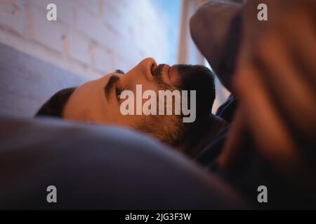 Homme inquiet de troubles du sommeil allongé sur le lit la nuit Banque D'Images