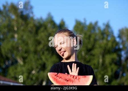 Jeune fille à main ouverte faisant signe d'arrêt refusant de prendre la pastèque tenu à elle. Perte d'appétit, concept d'anorexie Banque D'Images