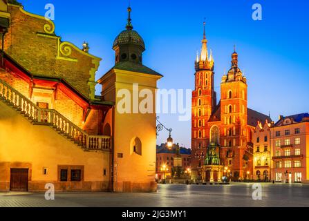 Cracovie, Pologne. L'église Sainte-Marie et la salle de la toile sur la place du marché principal à Cracovie, illuminées dans la nuit Banque D'Images