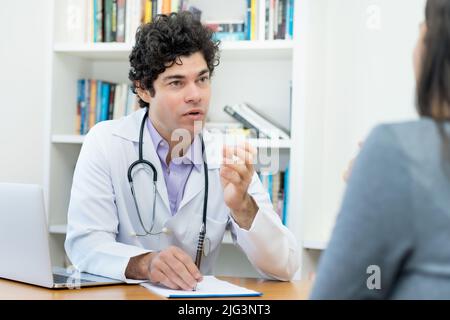 Médecin mature expliquant les problèmes à la patiente au bureau de l'hôpital Banque D'Images