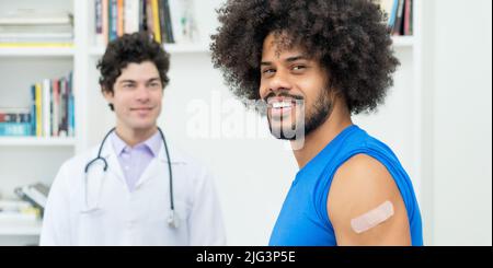 Rire de l'homme afro-américain avec un médecin après la vaccination contre Covid 19 comme protection contre le coronavirus Banque D'Images
