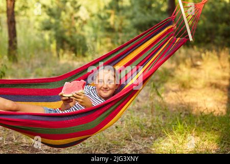 Petite fille mignonne de repos dans un hamac de couleur i Banque D'Images