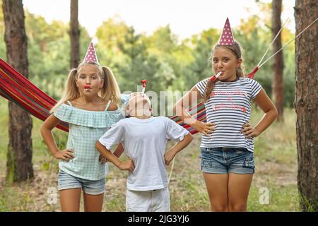 concept anniversaire, enfance et célébration - des cornes de fête soufflantes pour enfants heureux Banque D'Images