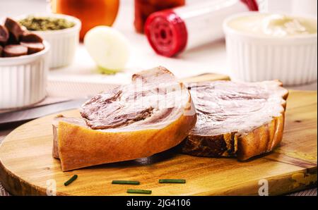 grand morceau de bacon cru et cuit, porc brésilien avec des ingrédients à l'arrière-plan, peau de porc et graisse. Banque D'Images
