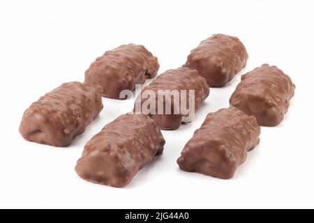 Morceaux croustillants de barres de chocolat disposés. Barres de chocolat aux arachides et au caramel. Vue rapprochée. Banque D'Images