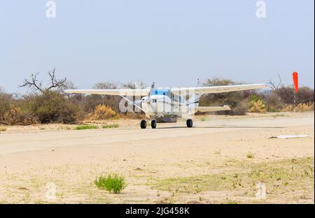 Un Cessna 172 sur la piste d'atterrissage de Chitabe desservant le camp de Sandibe, adjacent à la réserve de gibier de Moremi, dans le delta d'Okavango, au Botswana, en Afrique australe Banque D'Images