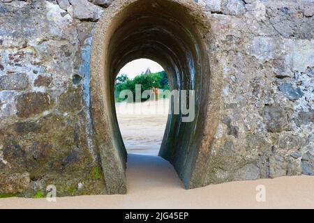 Tôt le matin, vue à travers une arche dans une jetée en pierre sur la plage Santander Cantabria Espagne Banque D'Images