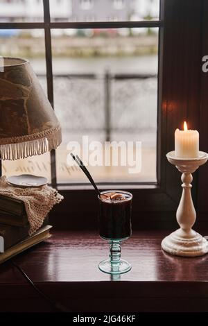 Boisson alcoolisée traditionnelle de fête en hiver. Un verre de vin chaud se trouve sur la fenêtre. Banque D'Images