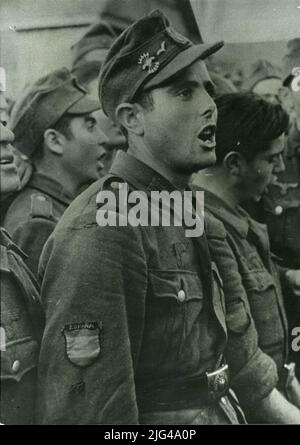 PHOTOGRAPHIE. Portrait de soldat espagnol, 1941. Scène des soldats espagnols en Russie chantant. Au premier plan, soldat non identifié. Le soldat porte un uniforme allemand avec un emblème de l'Espagne dans le manga et le fleuron métallique avec le joug et la casquette en chapeau Banque D'Images