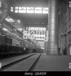 1950s, historique, à l'intérieur d'un des hangars géants de l'Abbey Steel Works, PortTalbot, pays de Galles, Royaume-Uni, montrant la voie ferrée traversant l'usine. Banque D'Images