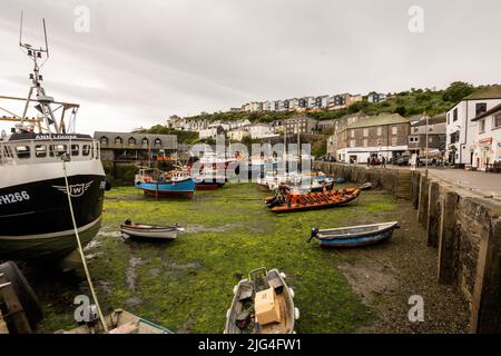 Les navires et les bateaux ont laissé haut et sec avec la marée basse au port de pêche de Mevagissey, Cornwall, Royaume-Uni Banque D'Images