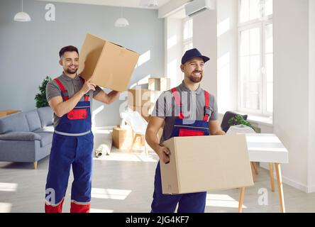 Les chargeurs de la société de déménagement et de livraison sortent les boîtes en carton de la salle de séjour. Banque D'Images
