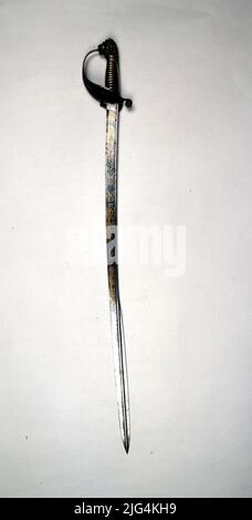 Sable pour officier de marine, modèle 1857. Sabre. Garniture d'alpaga dorée, formée par des étals complets avec une garde et un anneau de poulets. Il a l'arrière de la protection pliante par charnière, et dans la partie antérieure un ancrage sous la couronne royale. Il a un fist d'alpaga doré et Monterilla court du même métal. Ce qui forme la tête de Leon dans le bouton. Feuille incurvée avec loin rond à l'intérieur, qui forme la côte centrale sur la pointe, et le bord courir à l'étranger qui est doublé en elle. Ce sabre a une caisse en bois, bordée de cuir avec une plaque d'argent qui dit: «Les casinos nationaux de l'île de Cuba, à Don Dionisio Castilla/ en commemora Banque D'Images