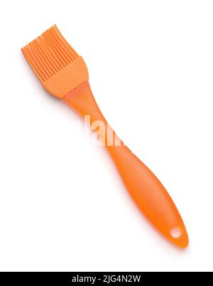 Brosse à badigeonner à l'huile de silicone orange de cuisine isolée sur blanc Banque D'Images