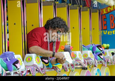 Les gens sur les manèges de carnaval pour s'amuser durant les vacances d'été à la Florida State Fair US barker carnie avec des tatouages Banque D'Images