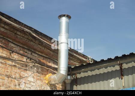 Tuyau sur le toit. Tuyau en acier pour fumée. Détails du bâtiment industriel. Banque D'Images