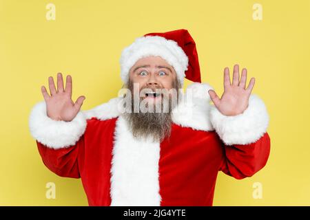 homme de grande taille dans le costume de noël en agitant les mains isolées sur le jaune Banque D'Images