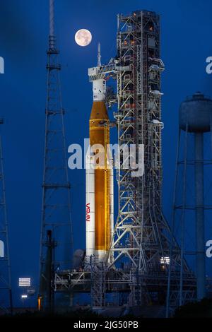 Une pleine lune s'élève au-dessus de la fusée Artemis I Space Launch System de la NASA avec l'engin spatial Orion à bord d'un lanceur mobile au Launch Complex 39B, au Kennedy Space Center, à 14 juin 2022, à Cape Canaveral, en Floride. Les SLS et Orion sont en cours de préparation pour une répétition de la robe humide afin de mettre en pratique les calendriers et les procédures de lancement. Banque D'Images