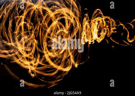 Flammes sur longue hache. Traces de feu dans l'obscurité. Les flammes se répandent chaotiquement dans l'espace. Banque D'Images