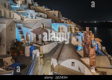 Vue sur le village d'Oia la nuit avec des maisons blanchies à la chaux typiques illuminées, Santorin, Grèce Banque D'Images