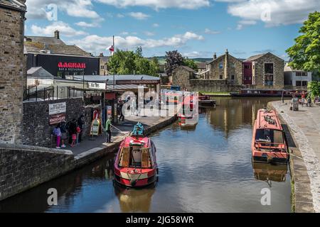 Des bateaux étroits sur le canal de la branche de Springs à des douves à côté de la jonction avec le canal Leeds-Liverpool lors d'une journée ensoleillée et lumineuse avec un ciel bleu. Banque D'Images