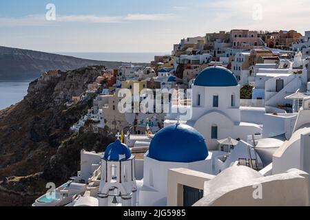 Vue sur Oia à Santorin, le village le plus célèbre de l'île avec les maisons blanches typiques et les églises en dôme bleu Banque D'Images
