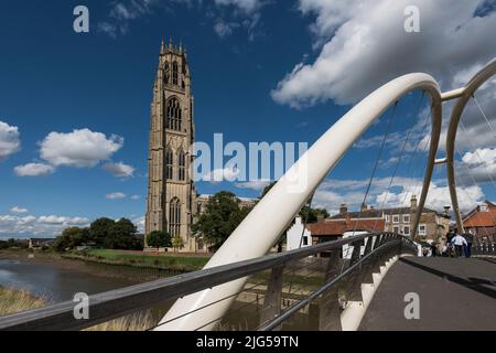 La tour de l'église de St Botolph et les personnes traversant la passerelle au-dessus de la rivière Witham sous un ciel bleu ensoleillé avec des nuages blancs. Banque D'Images