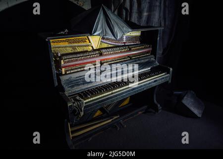 Vieux piano cassé dans la pièce sombre Banque D'Images