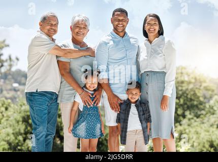 Je suis si fier de ma famille. Photo d'une famille multigénérationnelle debout à l'extérieur. Banque D'Images